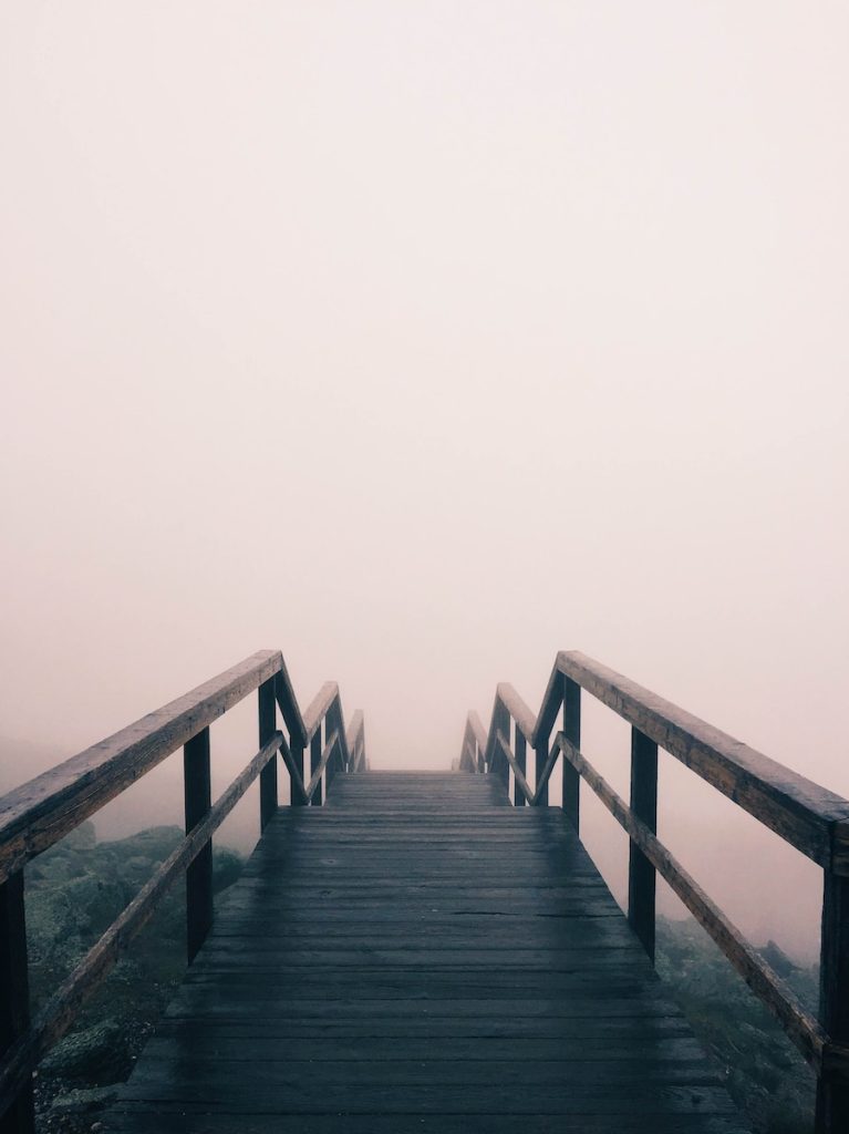 black wooden stairway covered with fog recadrée