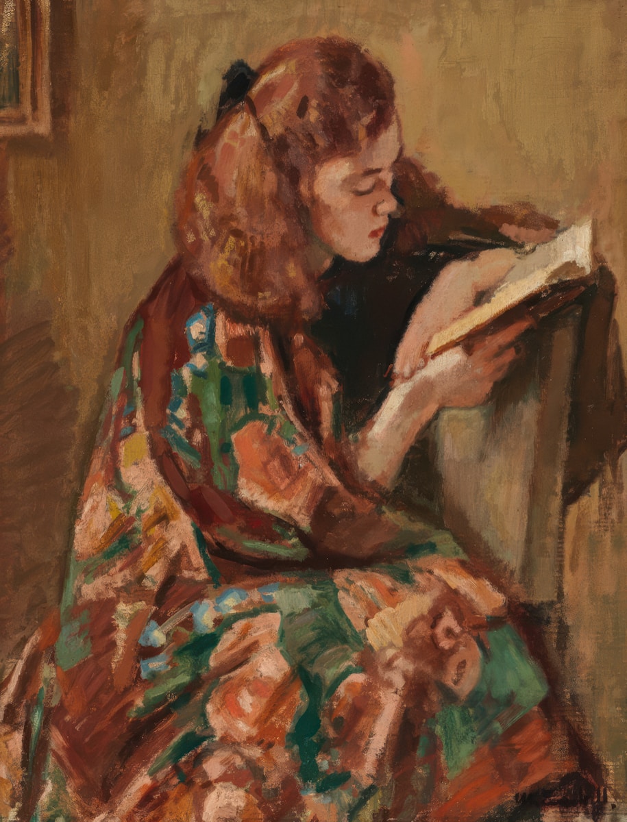 A woman reads a book while relaxing.