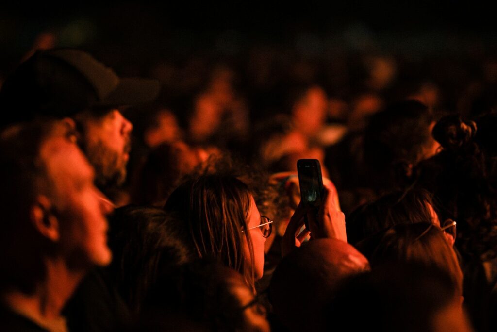 a crowd of people are watching a person take a picture of himself